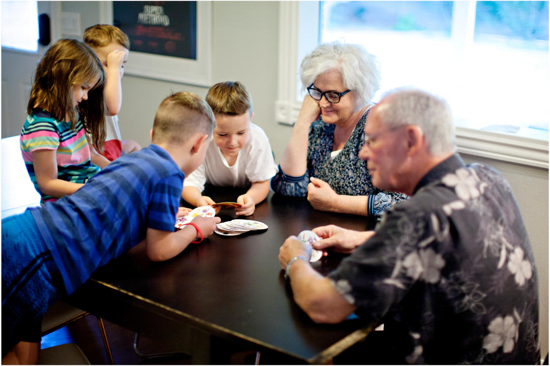 Image of kids playing card games with grandparents | Featured image for the Best Board Games for Grandparents Blog.