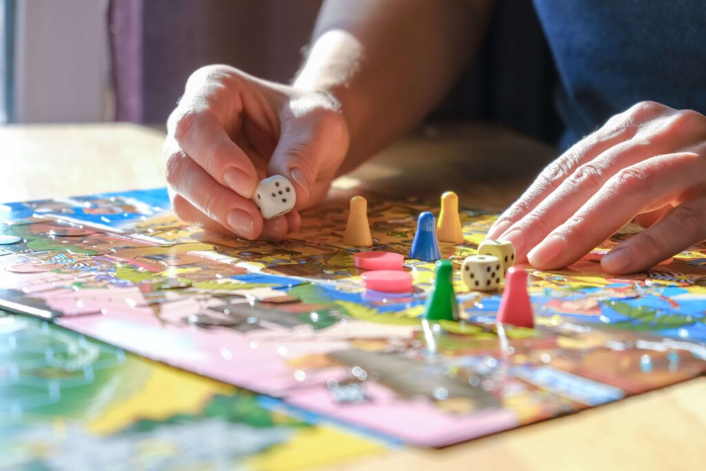 Close up of hands playing with board game pieces | Featured Image for Spiel des Jahres Winners 2023 blog post.