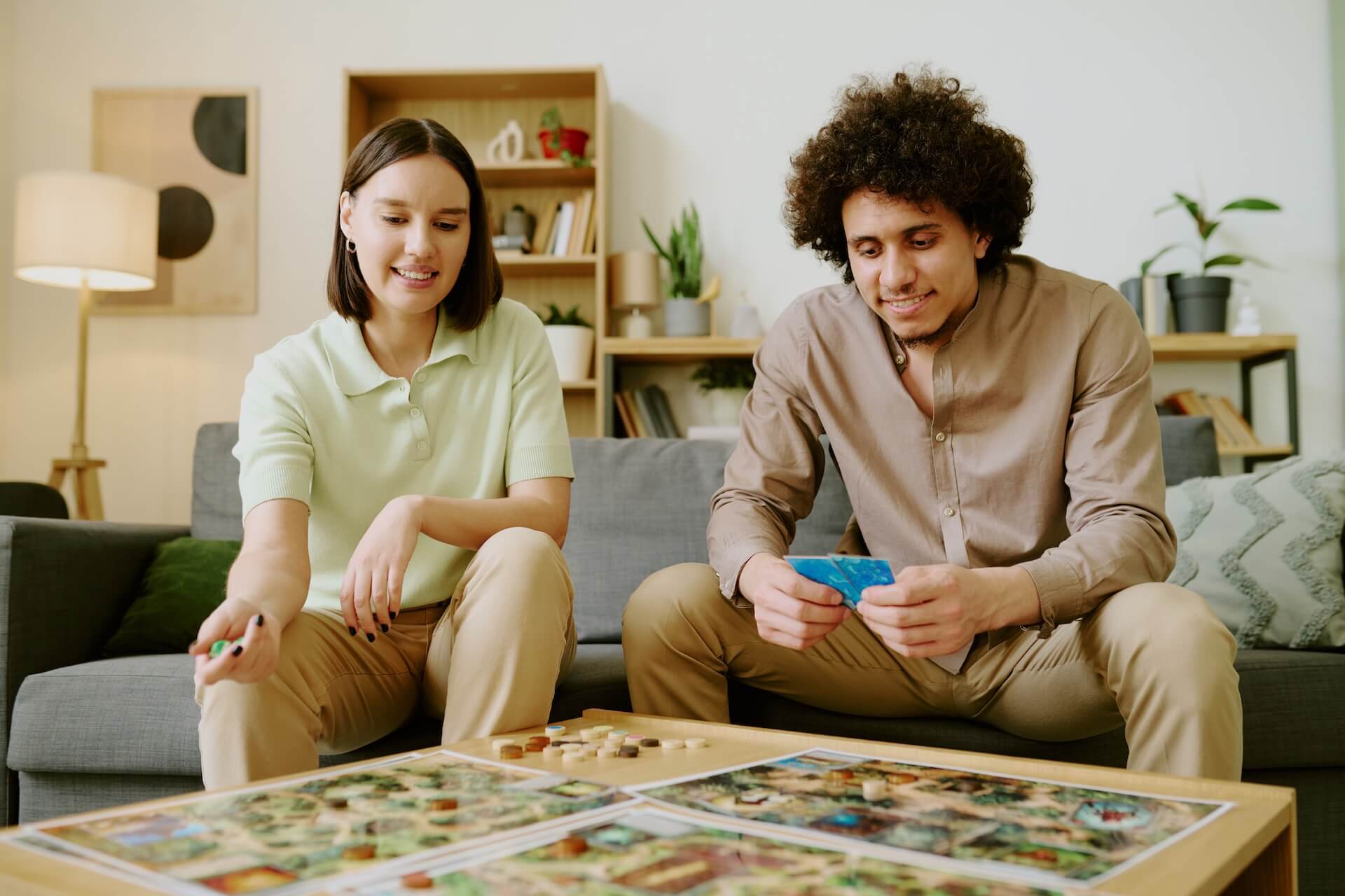 Two adults playing a board game | Featured Image for the Best Co-Op Games: Team Up and Take on the Challenge blog.