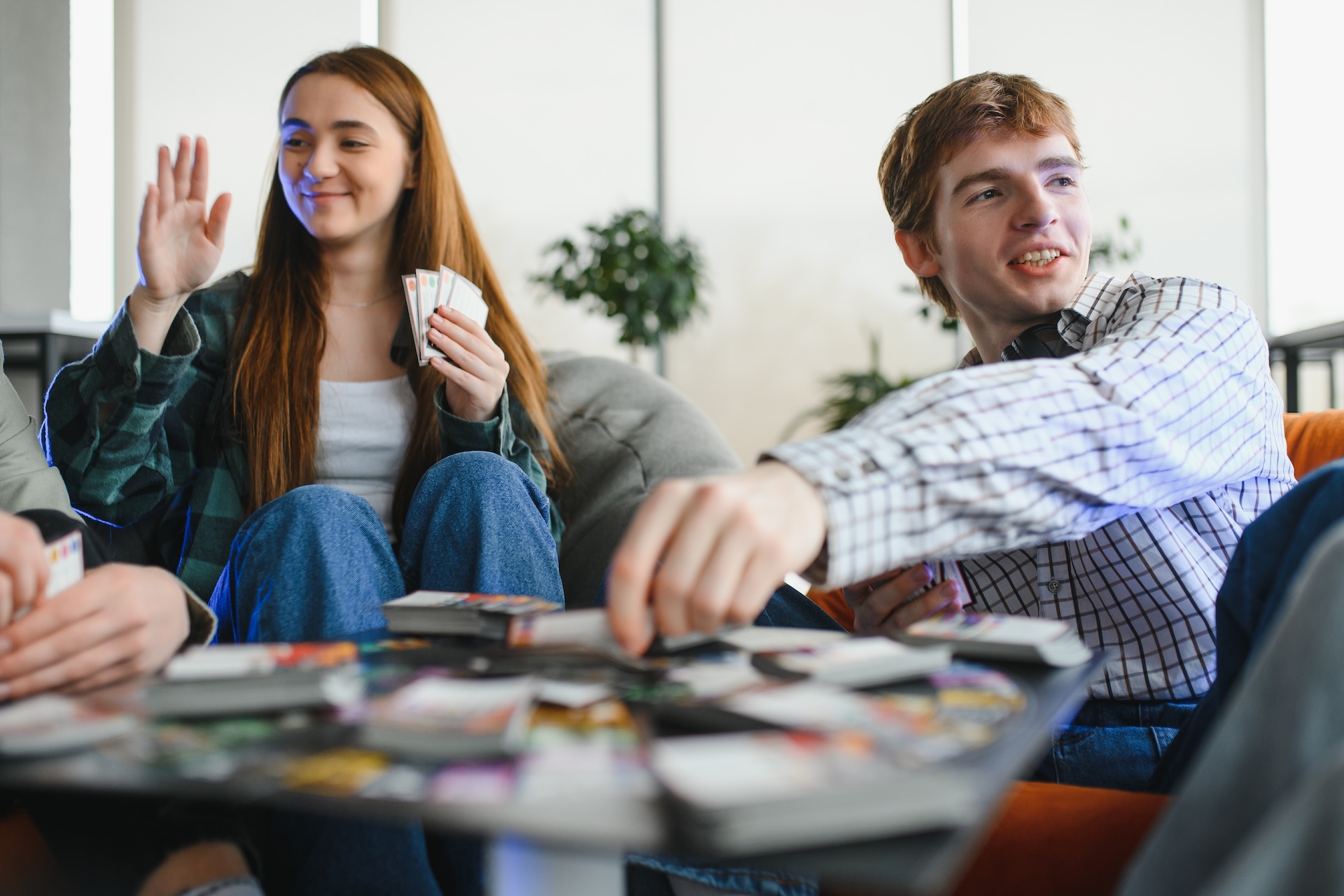 Group of friends enjoying a board game | Featured Image for the Engine-Building Games That Feel Amazing When They Click blog.