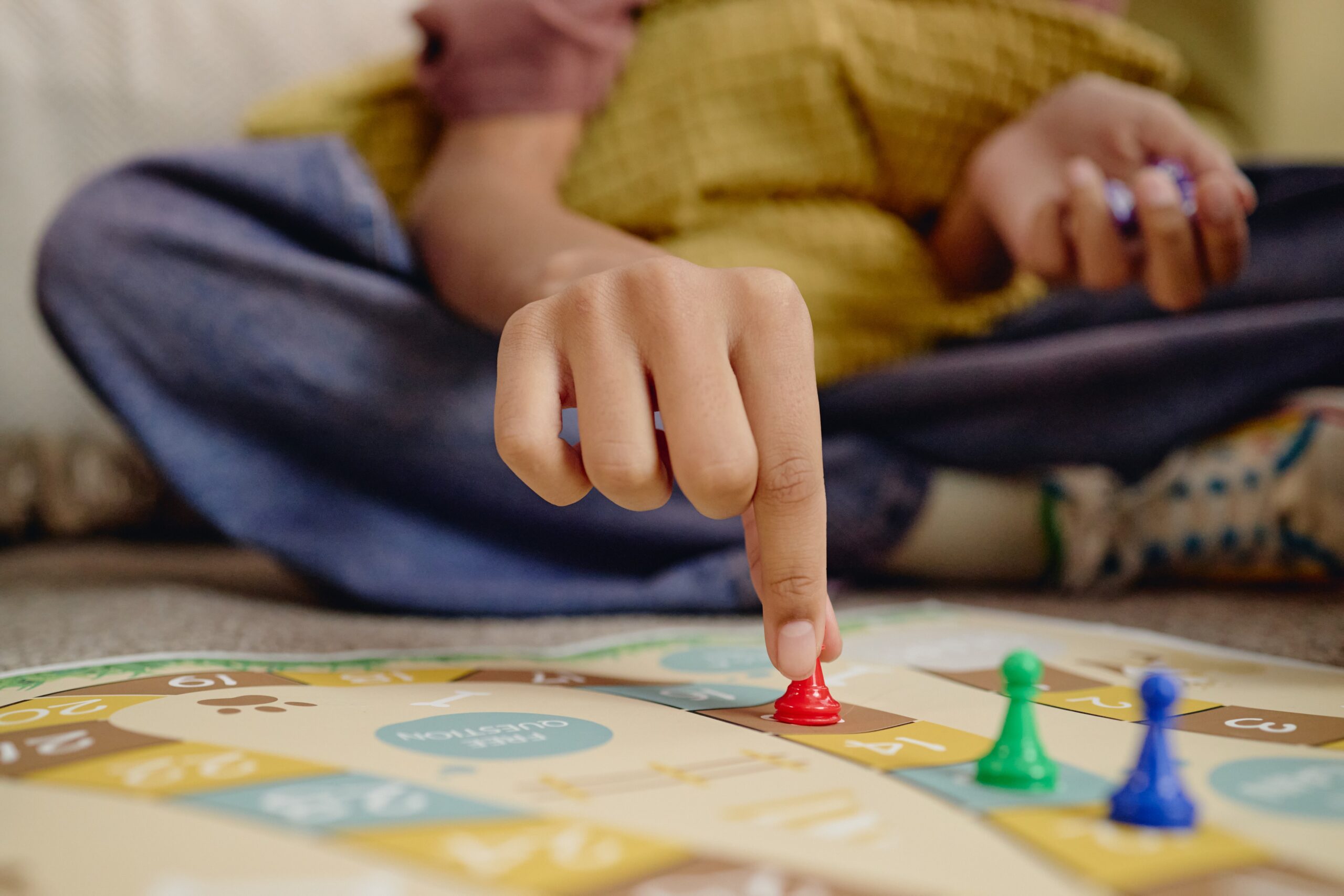 Child Plays Colorful Board Game at Home