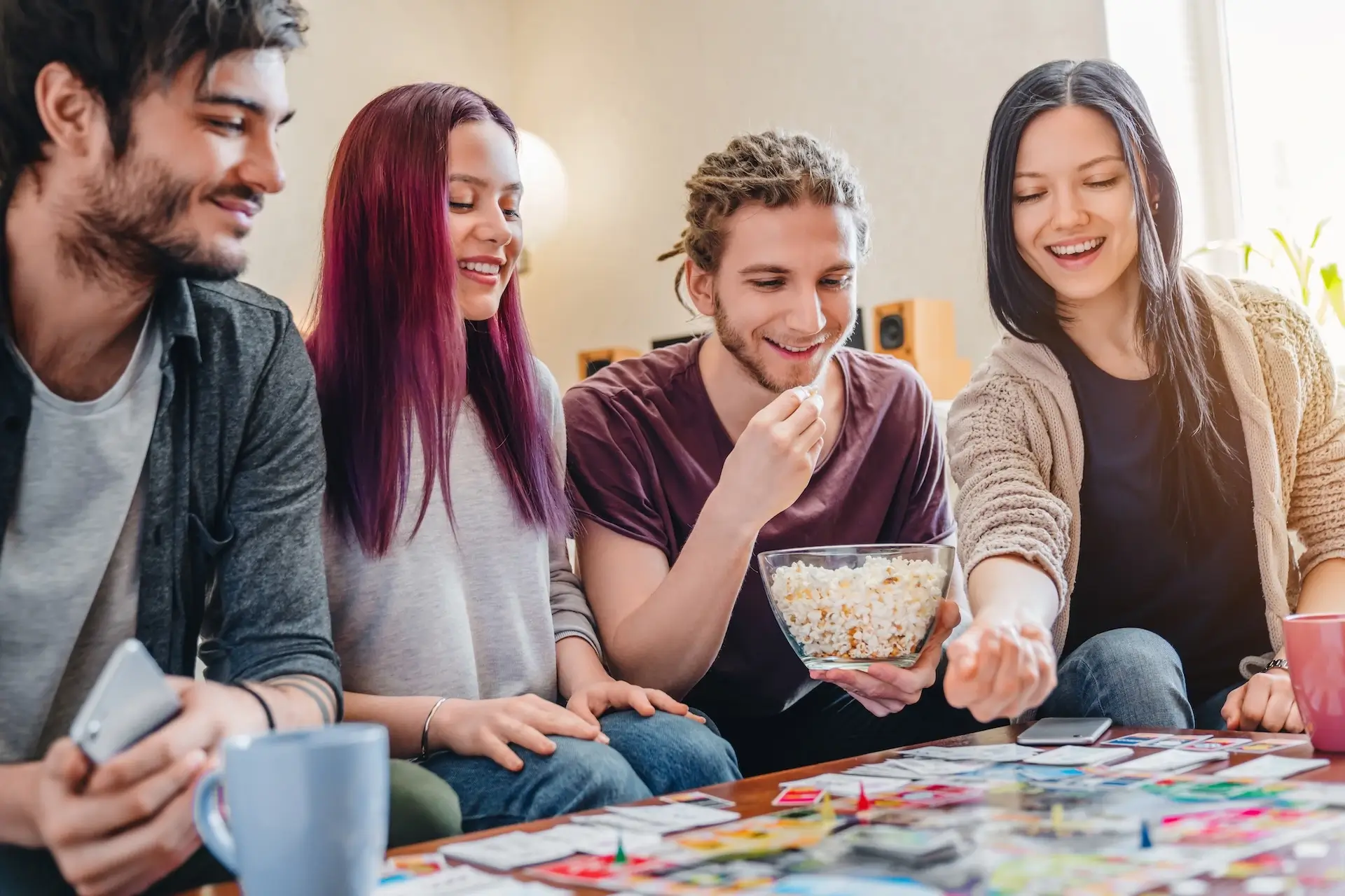 Group of friends gathered around a table to play board games | Featured Image for the Sci-Fi Showdowns: Best Futuristic Board Games blog.